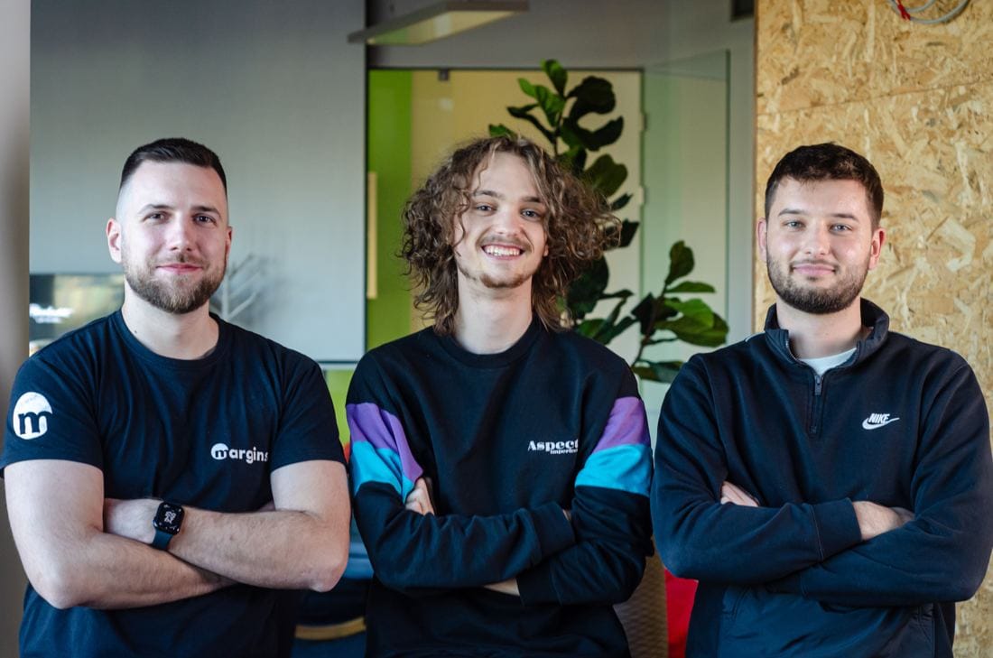 Three Margins engineers standing with arms crossed, smiling